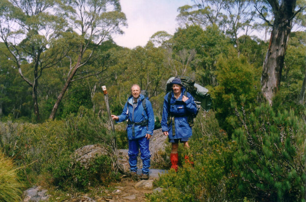Eric Robinson and John Sidwell stand in hiking clothes on a hiking trail in Tasmania