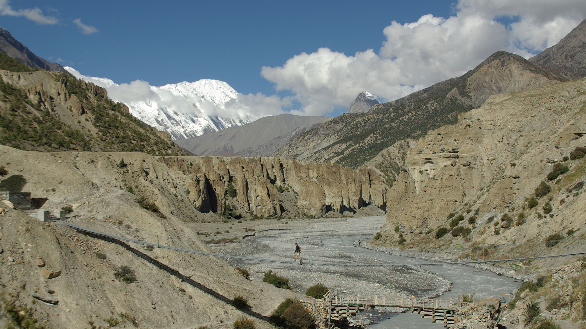 Eric Robinson crosses a suspension bridge on the Annapurna Circuit in Nepal in 2009.