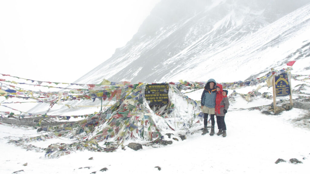 Eric Robinson and Marilyn Koolstra stand on a snowy mountain pass in Nepal