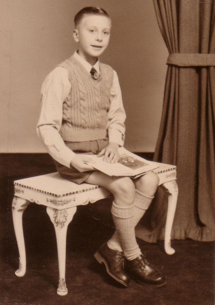 Adolescent Eric Robinson poses holding a book