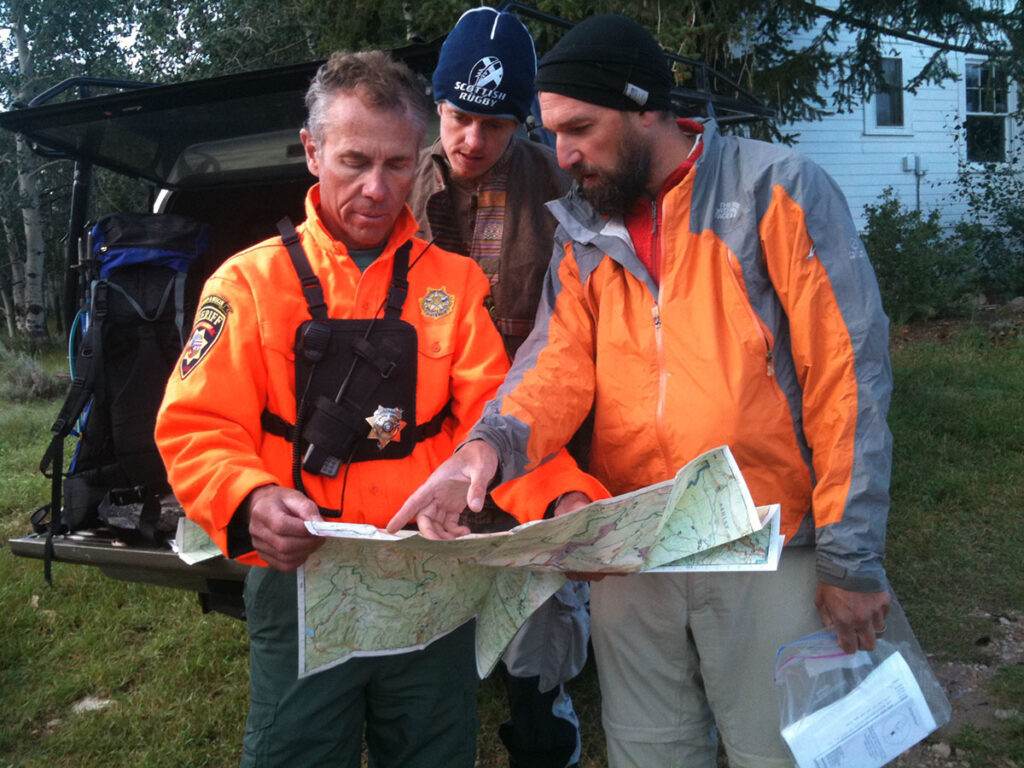 Three men look at a trail map of the High Uintas Wilderness