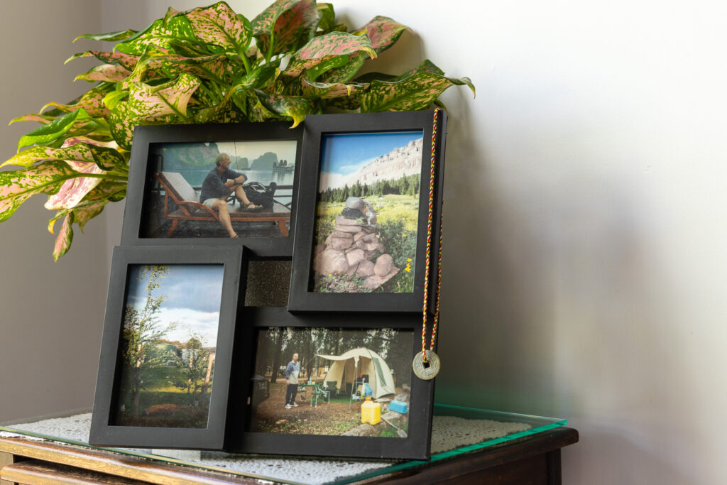 A picture frame containing four photos representing the life of Eric Robinson sits on a small table